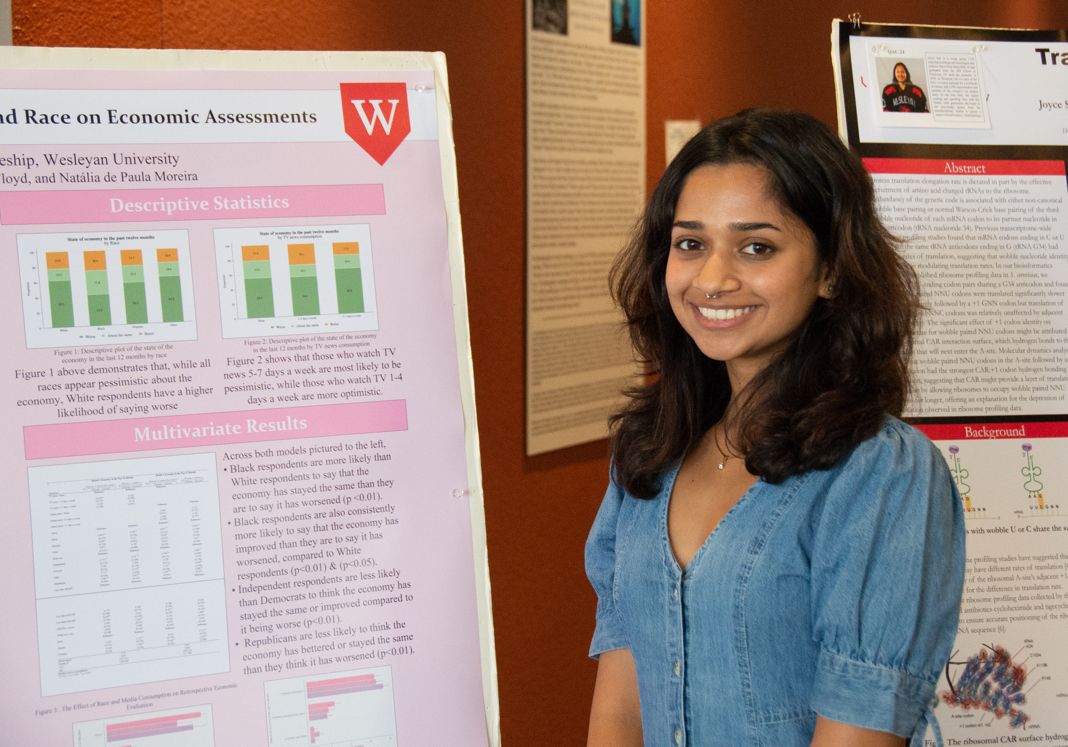 a young woman smiles beside her poster